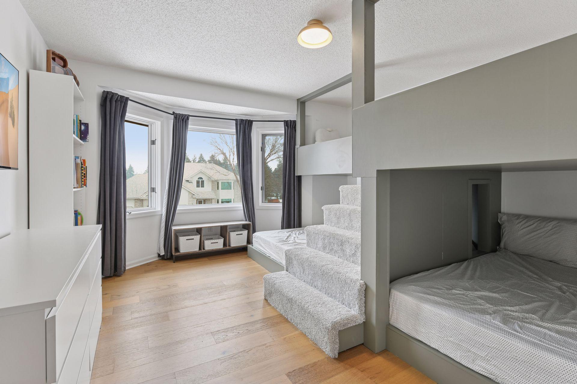 A beautifully crafted built-in bunk room that comfortably sleeps four — complete with bright lighting and the perfect atmosphere for movie nights, sleepovers, and fun fill this third bedroom of the four upper level bedrooms..