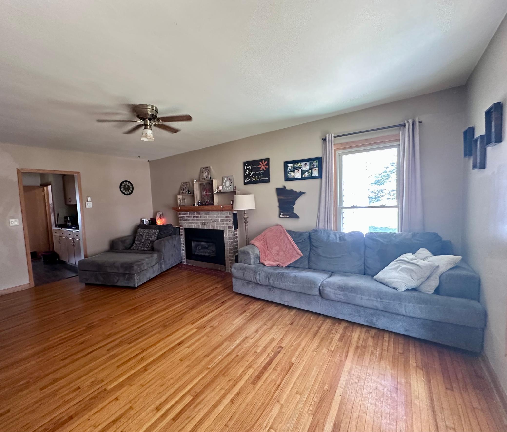 Large living room space includes brick fireplace...