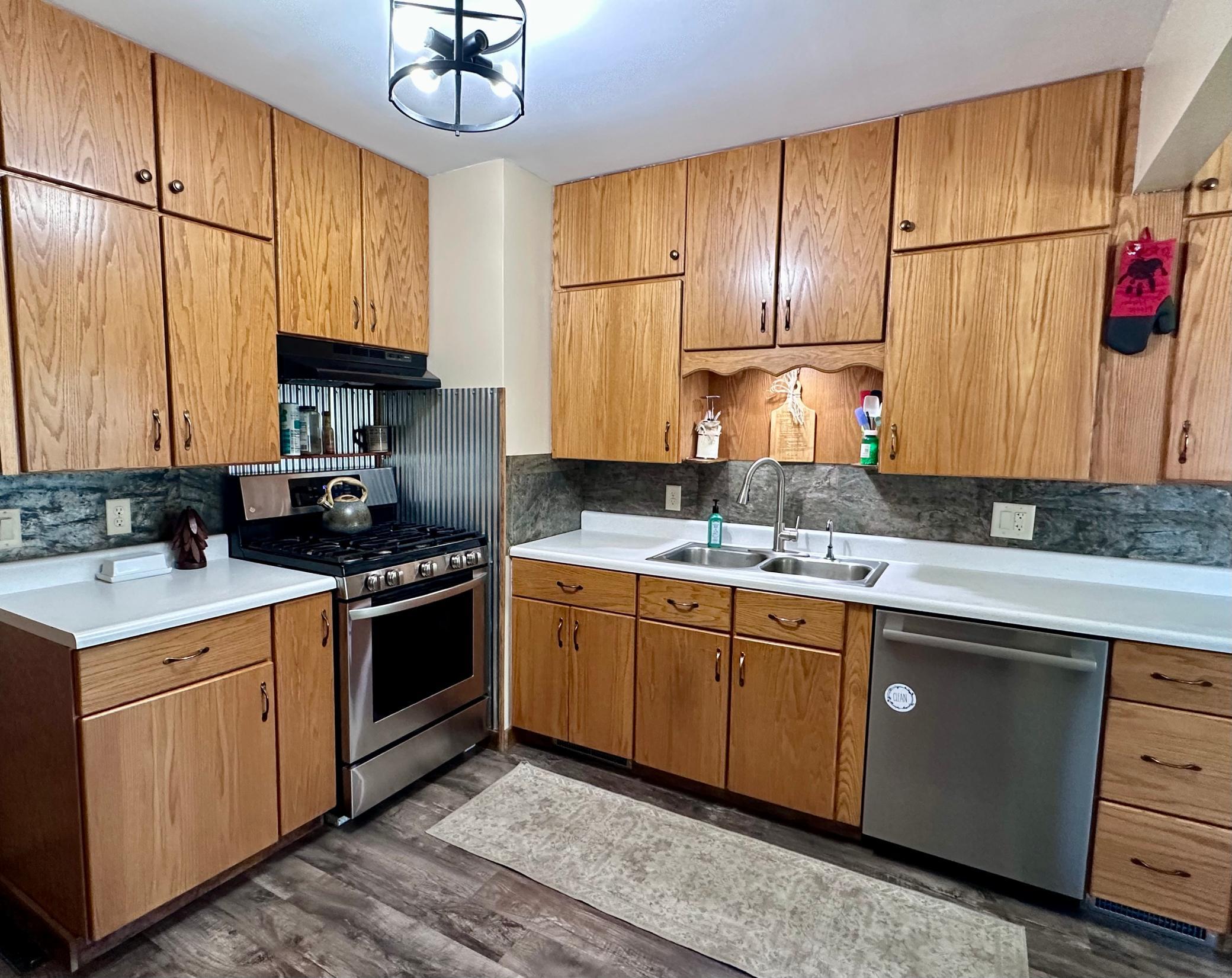 Refinished kitchen space features newer appliances, aspect stone tile backsplash, updated flooring...
