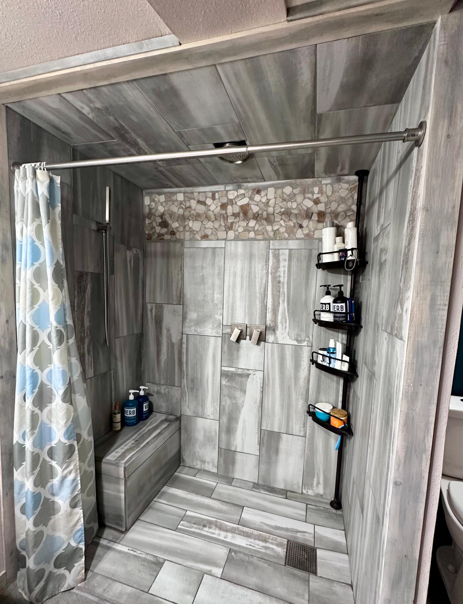 Featuring a rain shower surrounded by custom tile work.