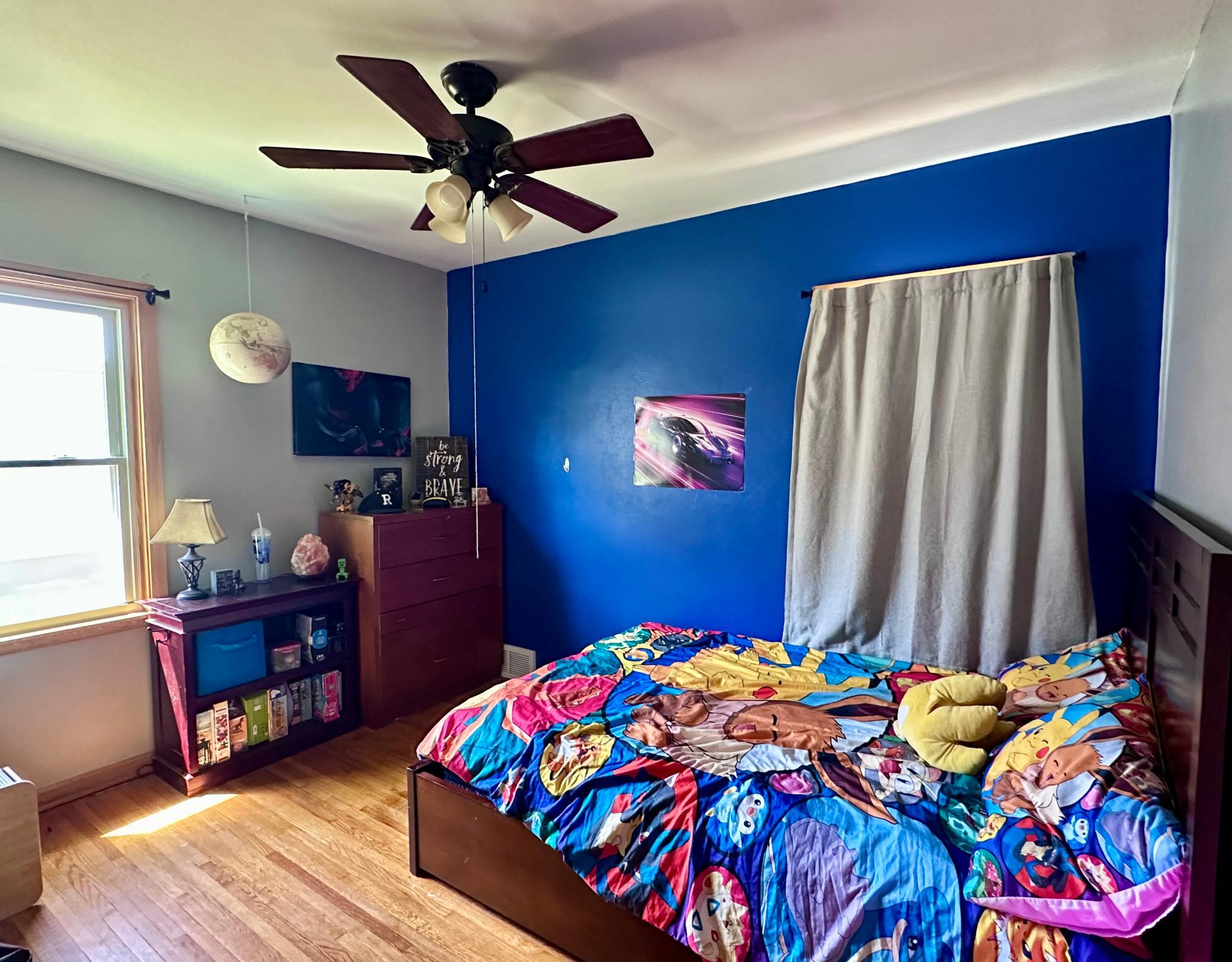 Bedroom 1 on main floor features the original hardwood and a ceiling fan.