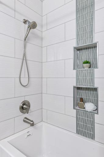 Updates to main level full bath also include a soaker tub and stunning tile work.