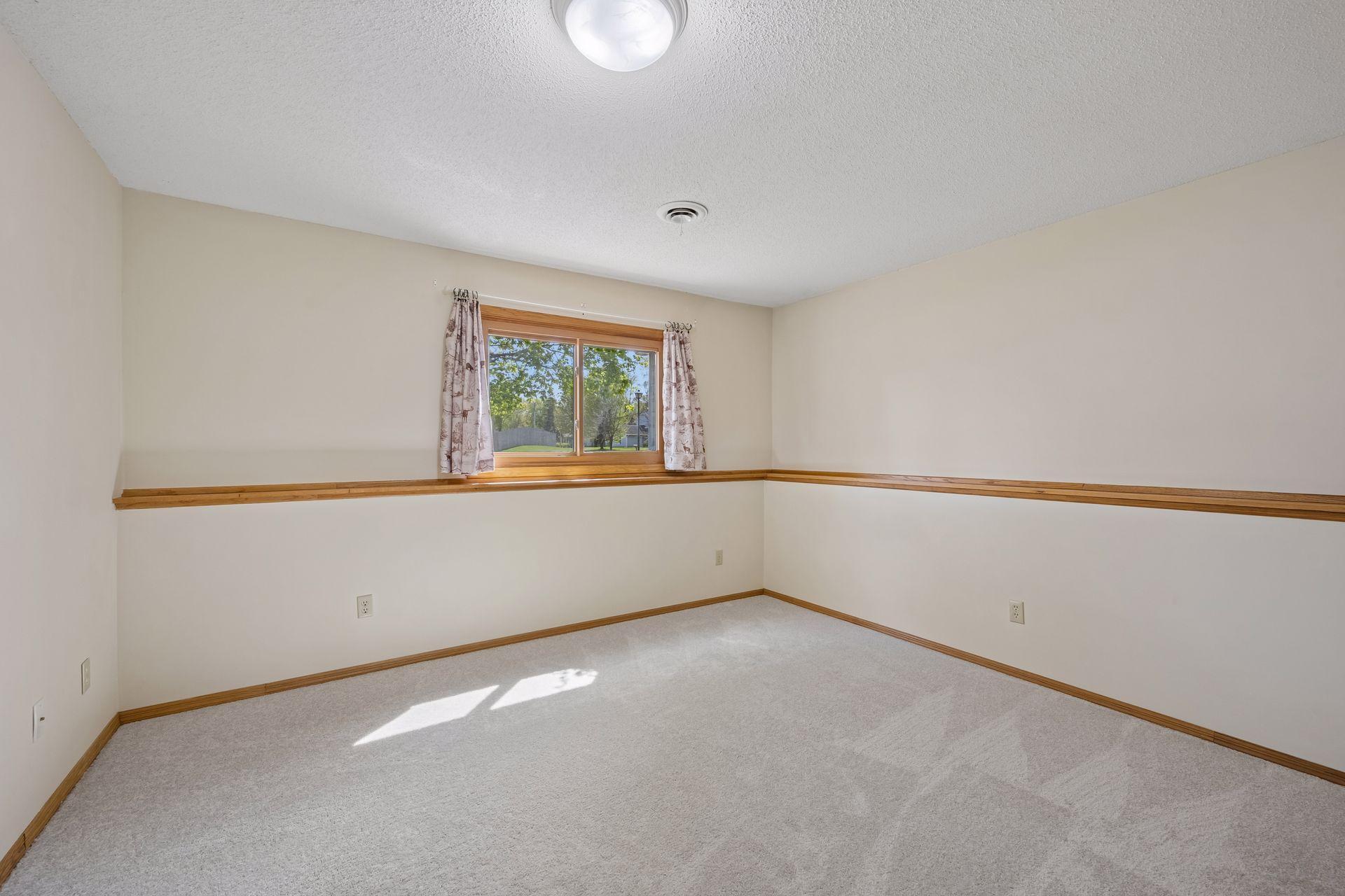 Lower level bedroom with views out to the front yard and that gorgeous maple tree!