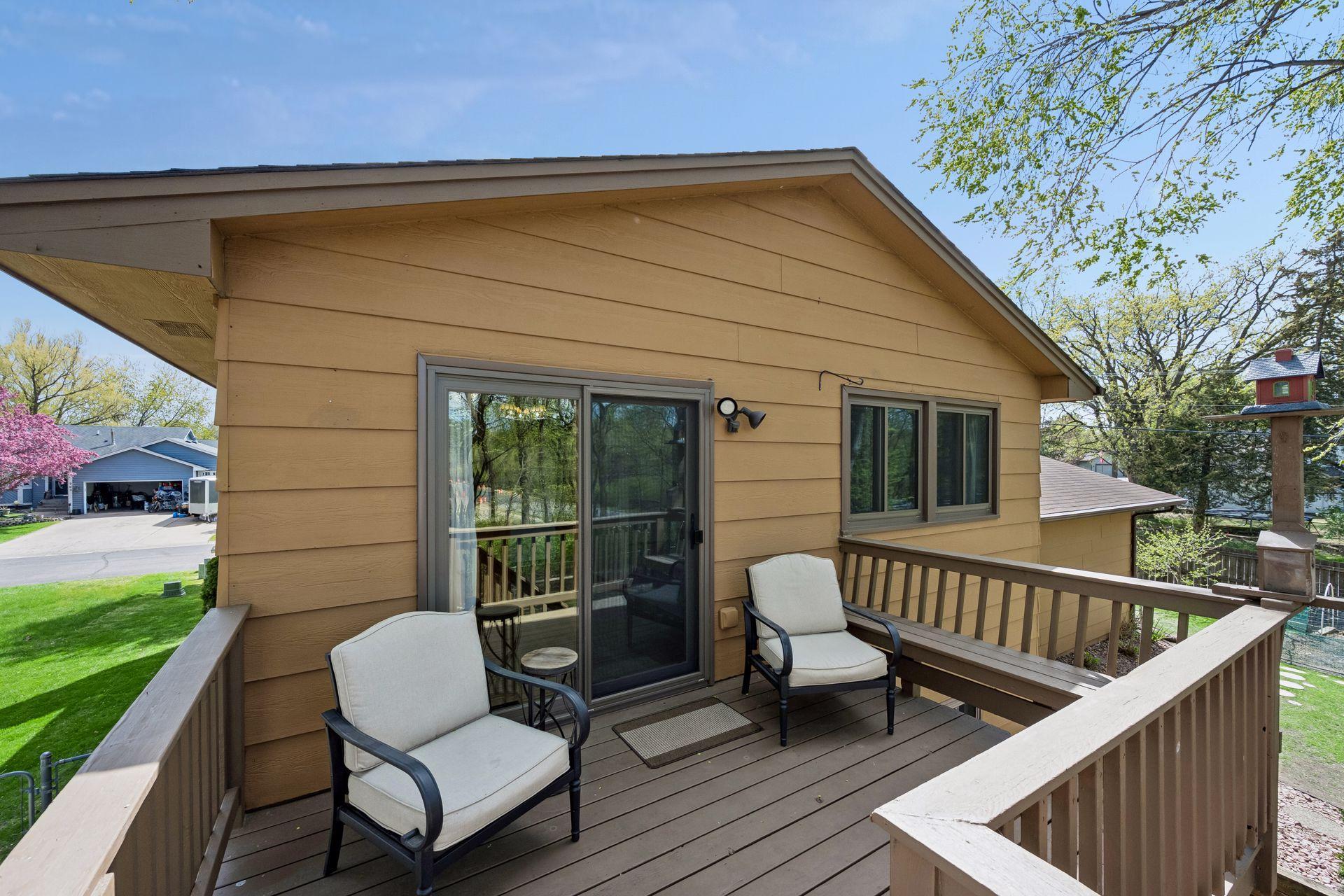Deck off the kitchen overlooks wooded landscape with mature trees
