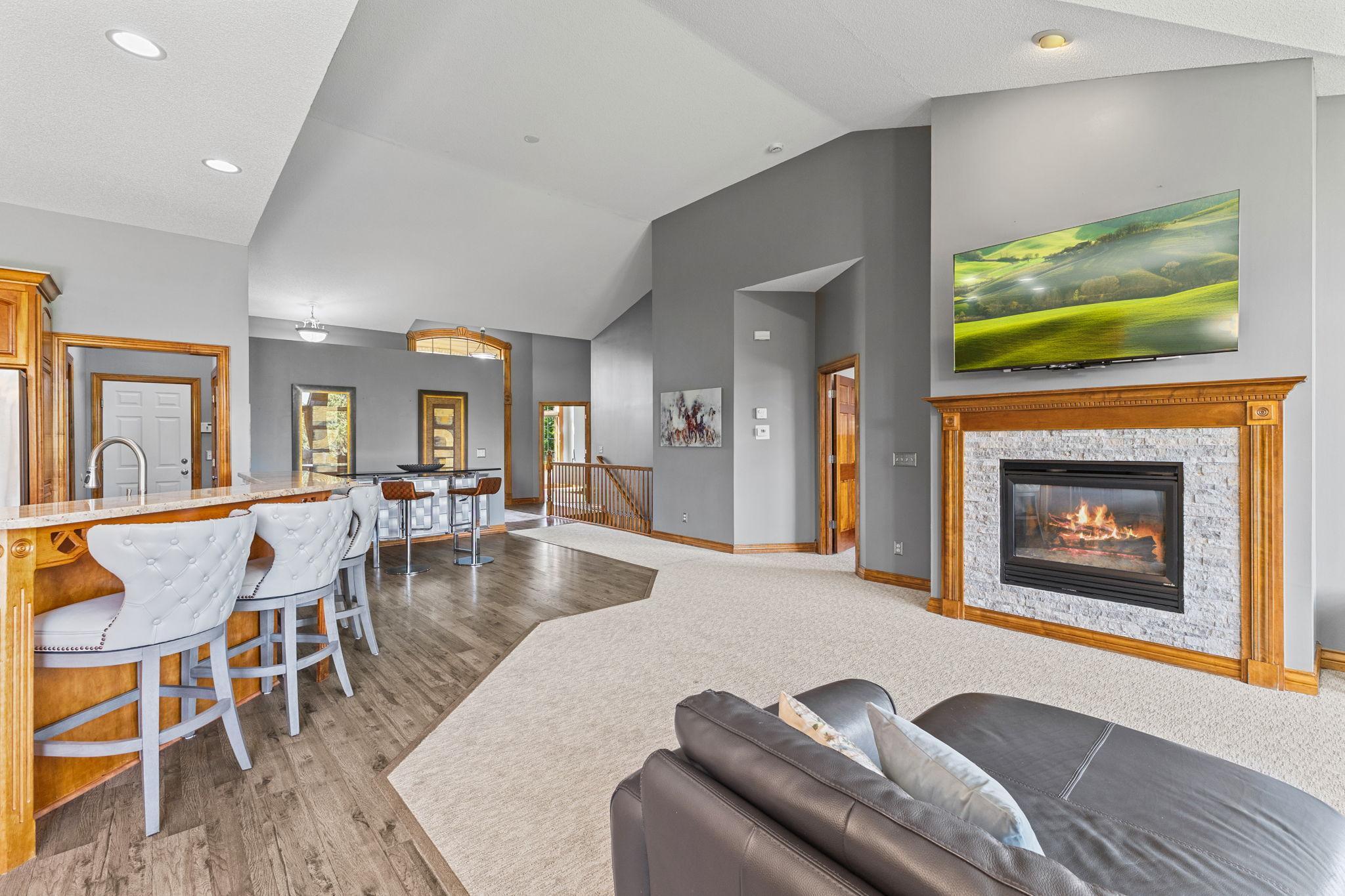 The cozy gas fireplace offers a stunning modern focal point with the newer custom natural brick surround. Vaulted ceilings create a grand feel to the main level living room.