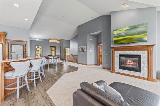 The cozy gas fireplace offers a stunning modern focal point with the newer custom natural brick surround. Vaulted ceilings create a grand feel to the main level living room.