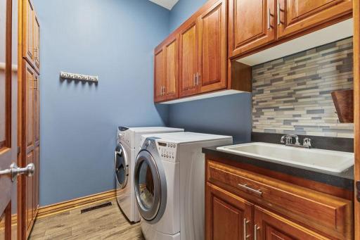 Main level spacious laundry room with ample storage and folding surfaces.