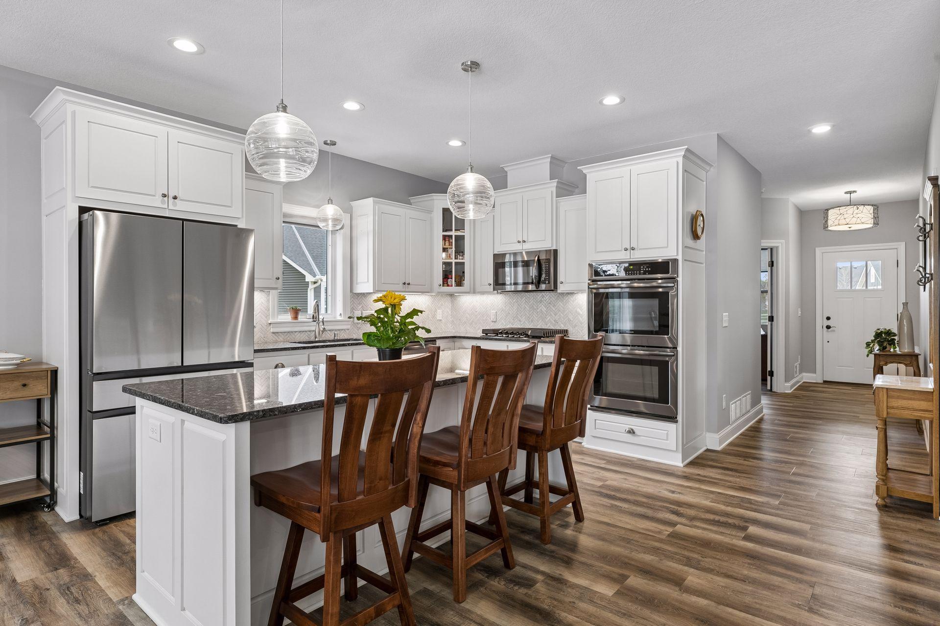 Open and bright kitchen with variegated height upper cabinet design and large center island.