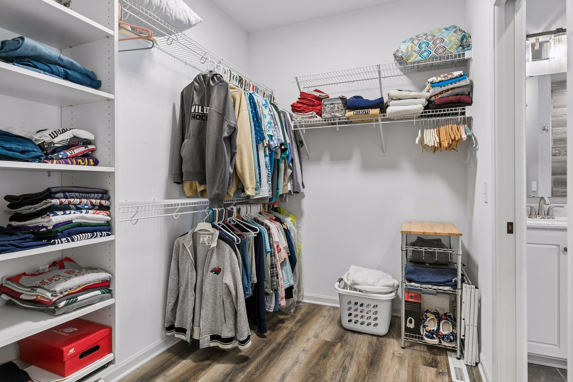 Large Primary Bedroom walk-in closet. Tiered hanging, along with built-in shelves.