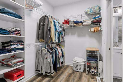 Large Primary Bedroom walk-in closet. Tiered hanging, along with built-in shelves.