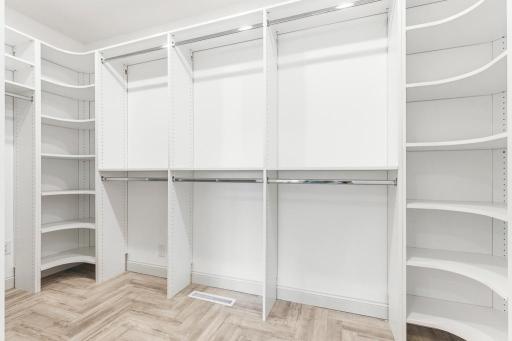 Large walk-in closet in the primary bedroom with custom built-ins