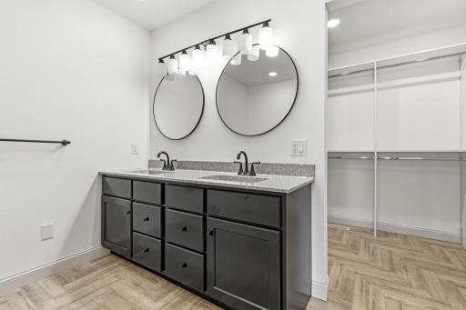 Ensuite primary bath features a dual vanity. walk-in shower, soaker tub, and large walk-in closet.