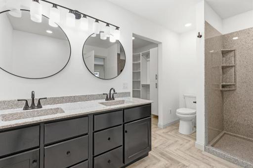 Ensuite primary bath features a dual vanity. walk-in shower, soaker tub, and large walk-in closet.