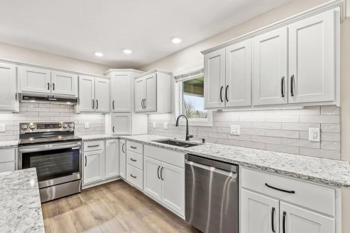 Dakota slow-close cabinetry, under cabinet lighting, tile backsplash, and brand new finger print resistant appliances