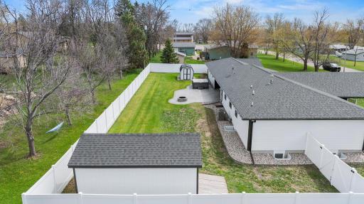 Beautiful view of the backyard layout, bonus storage sheds, and the stamped concrete patio/firepit.