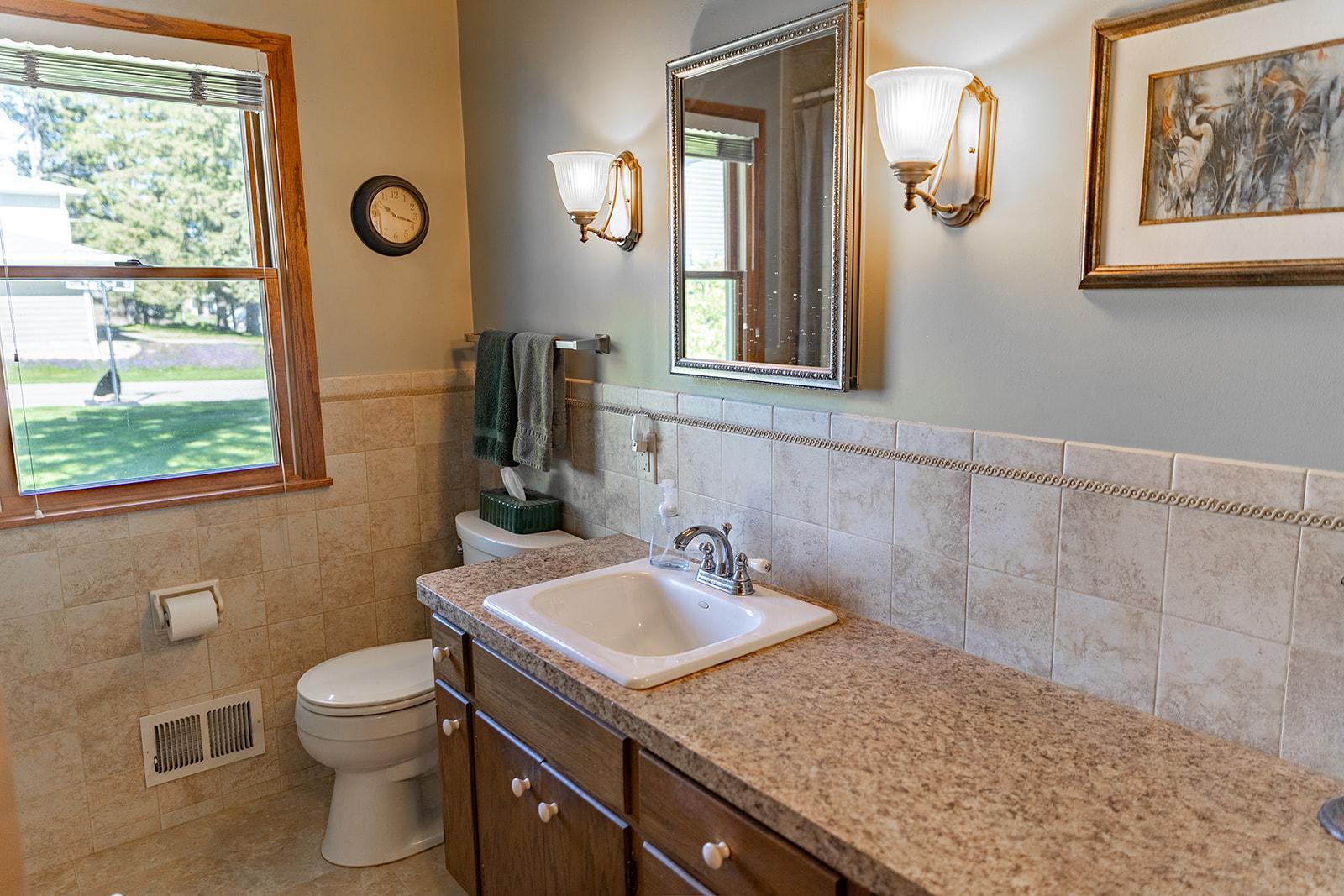 Updated main-level full Bath includes a ceramic tile shower