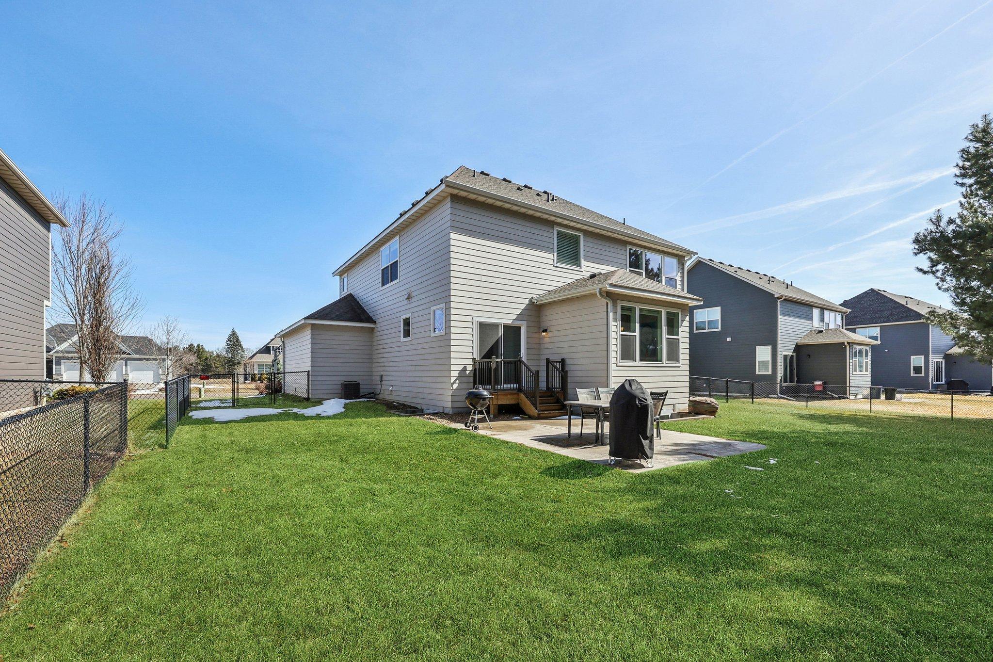 Fully fenced backyard with patio space, deck access, and room for outdoor entertaining or play.