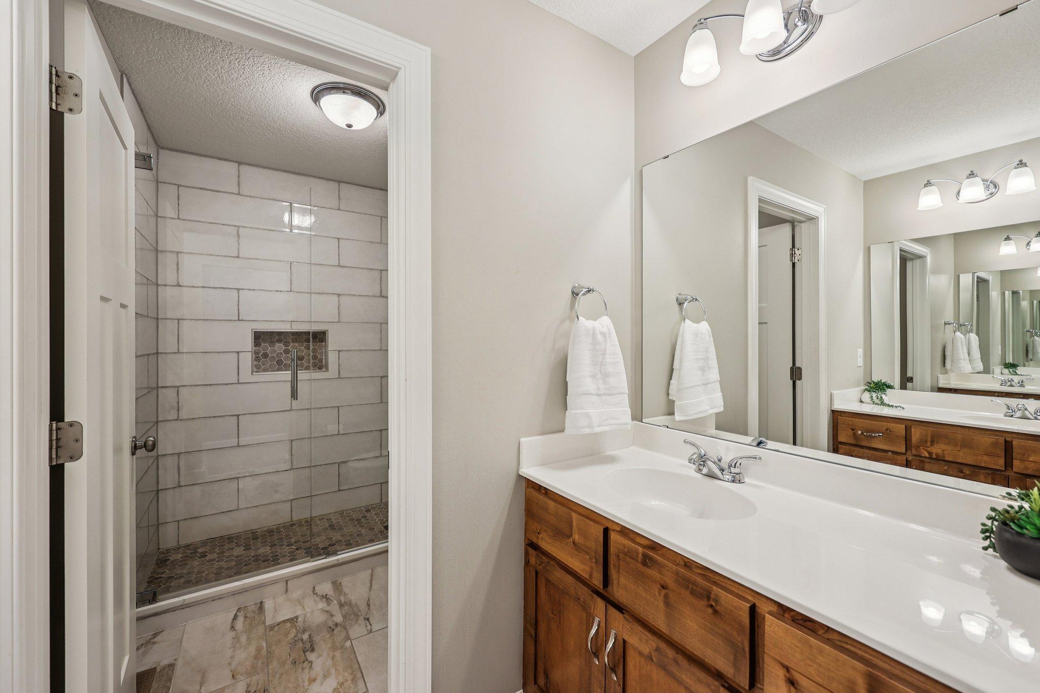 Updated upper level bathroom with double vanity and refreshed finishes completed in 2021.