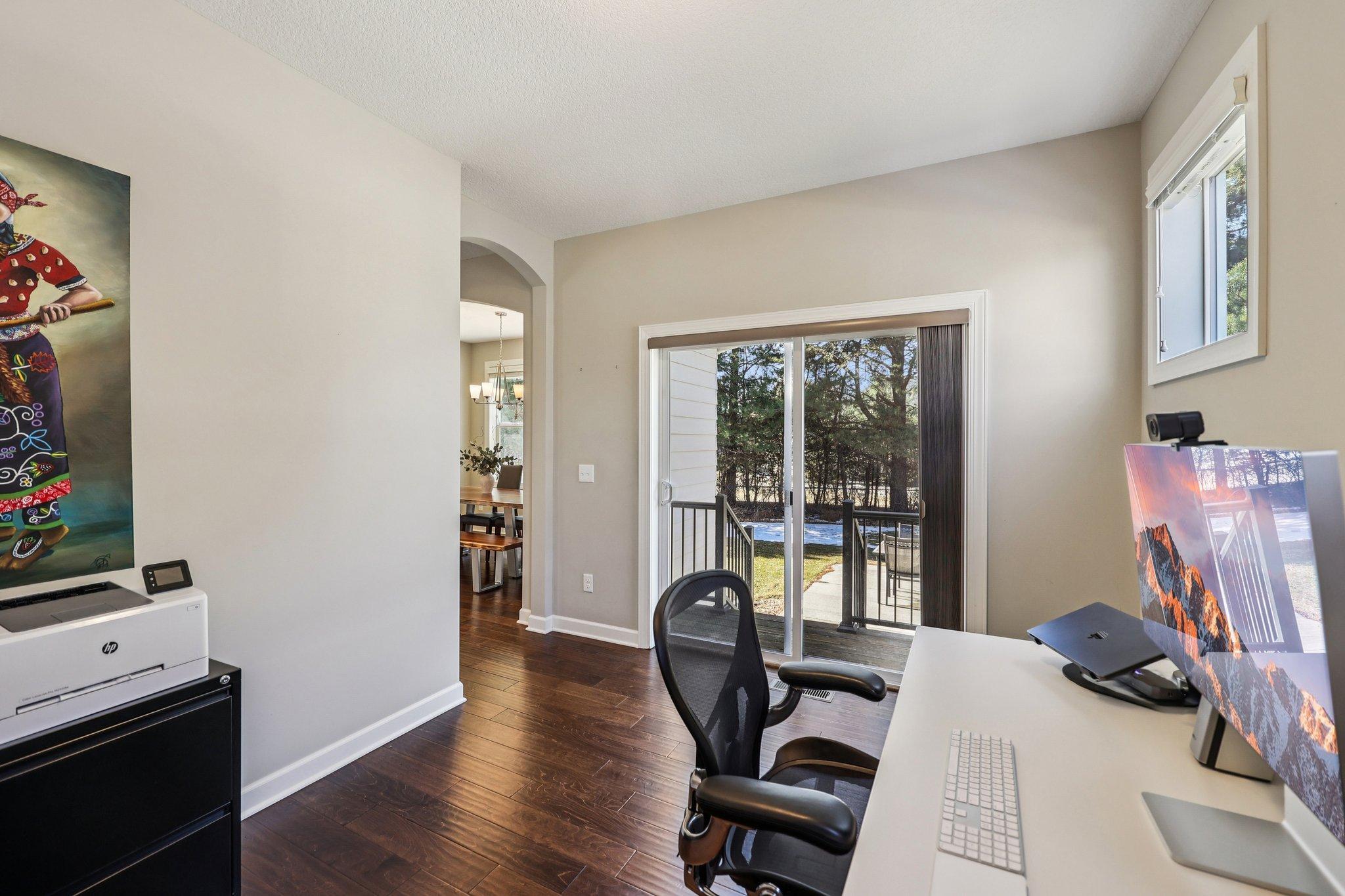 Main level flex room ideal for home office, study space, or additional sitting area with access to backyard patio.