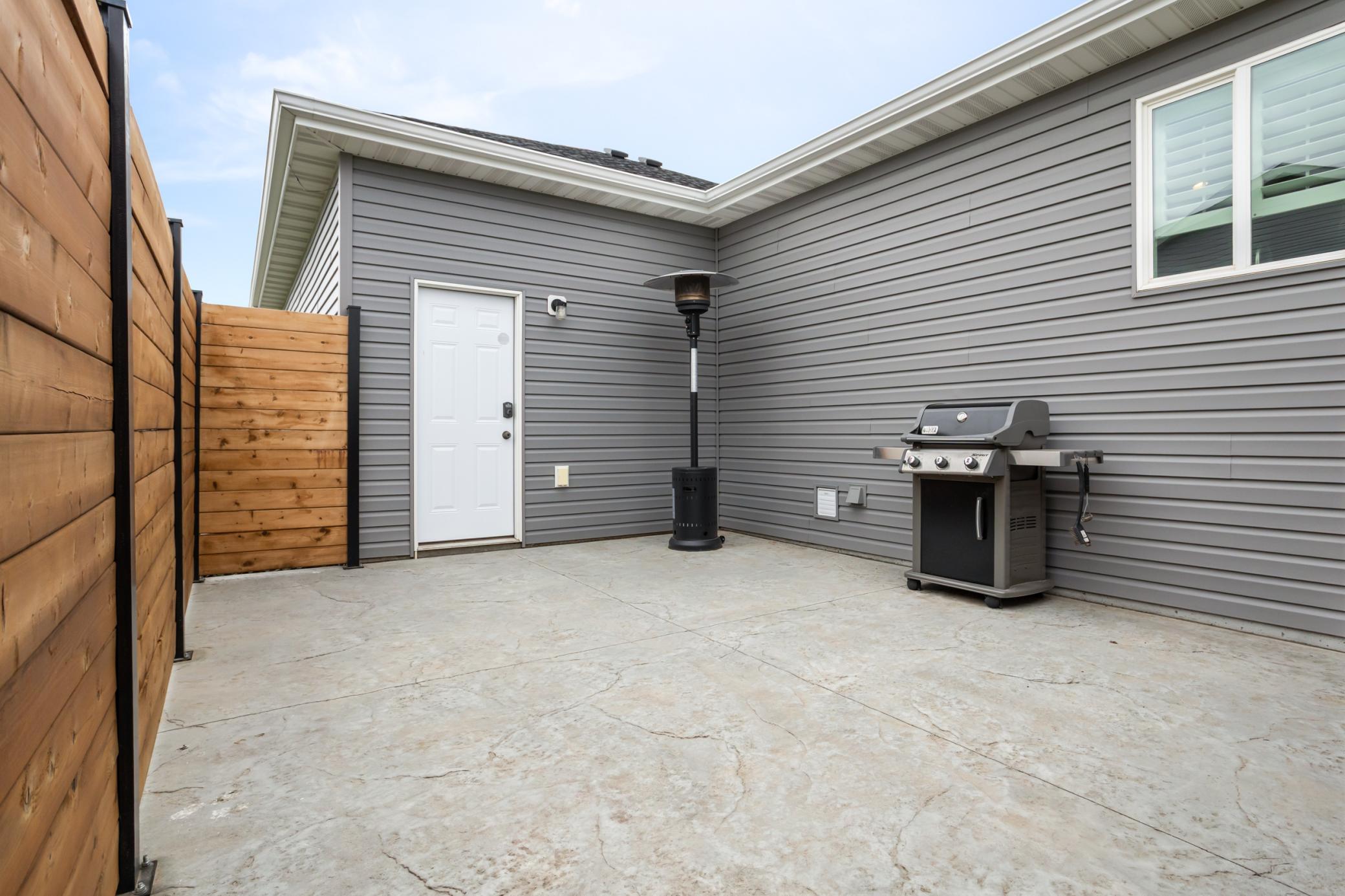 Fenced in patio behind garage