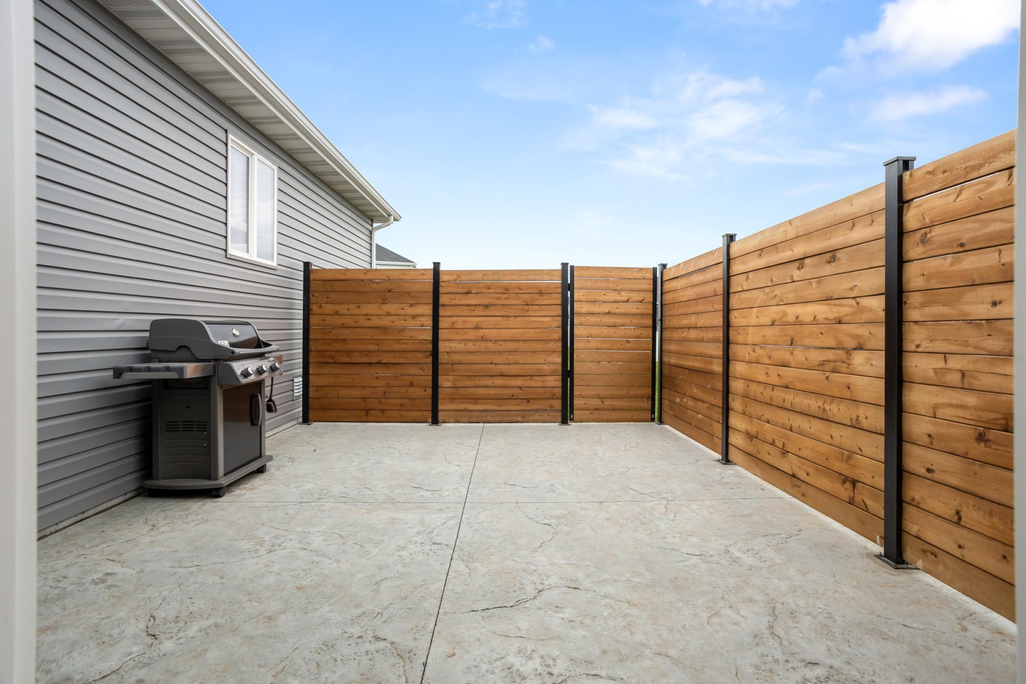 Fenced in patio space behind garage