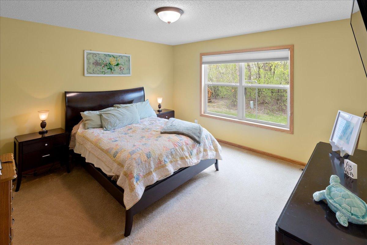 Primary bedroom has a great view of the nature filled wooded backyard.