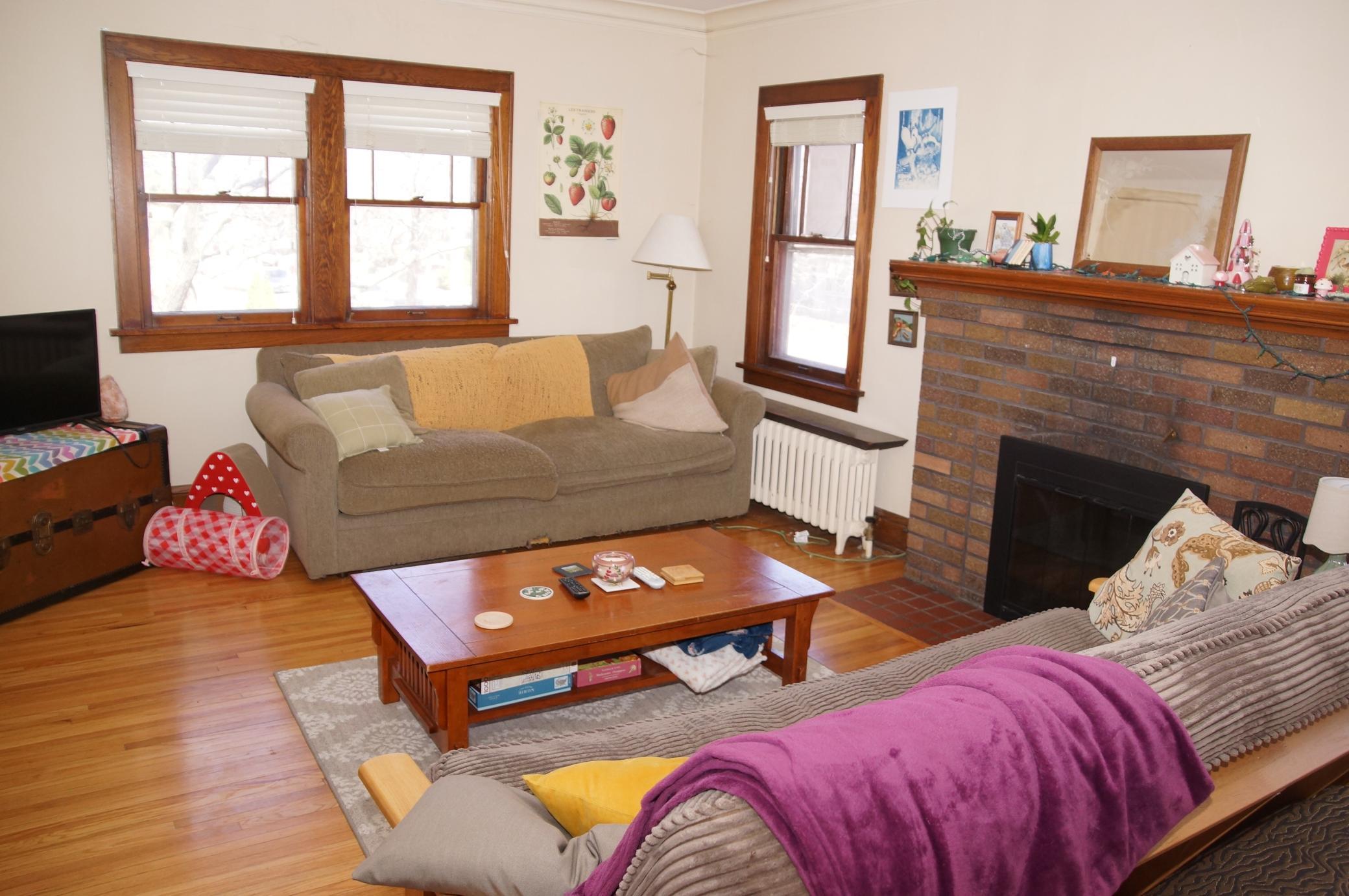 Living room with Hardwood floors, Classic Woodwork and Wood burning fireplace!