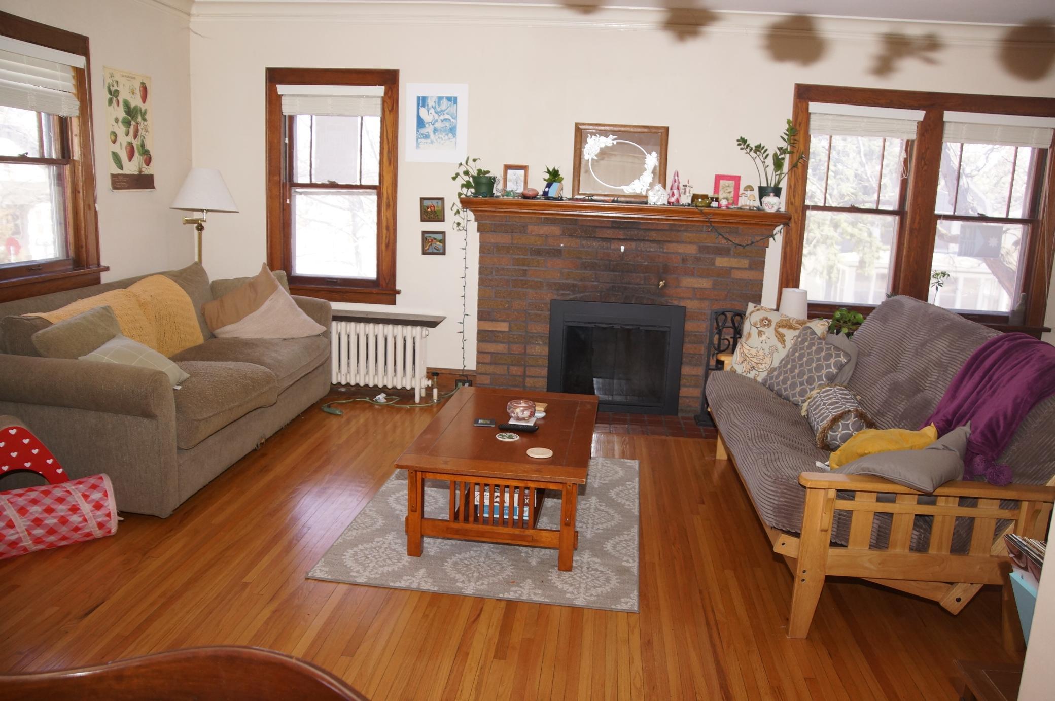 Living room with Hardwood floors, Classic Woodwork and Wood burning fireplace!