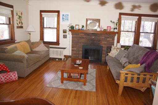 Living room with Hardwood floors, Classic Woodwork and Wood burning fireplace!
