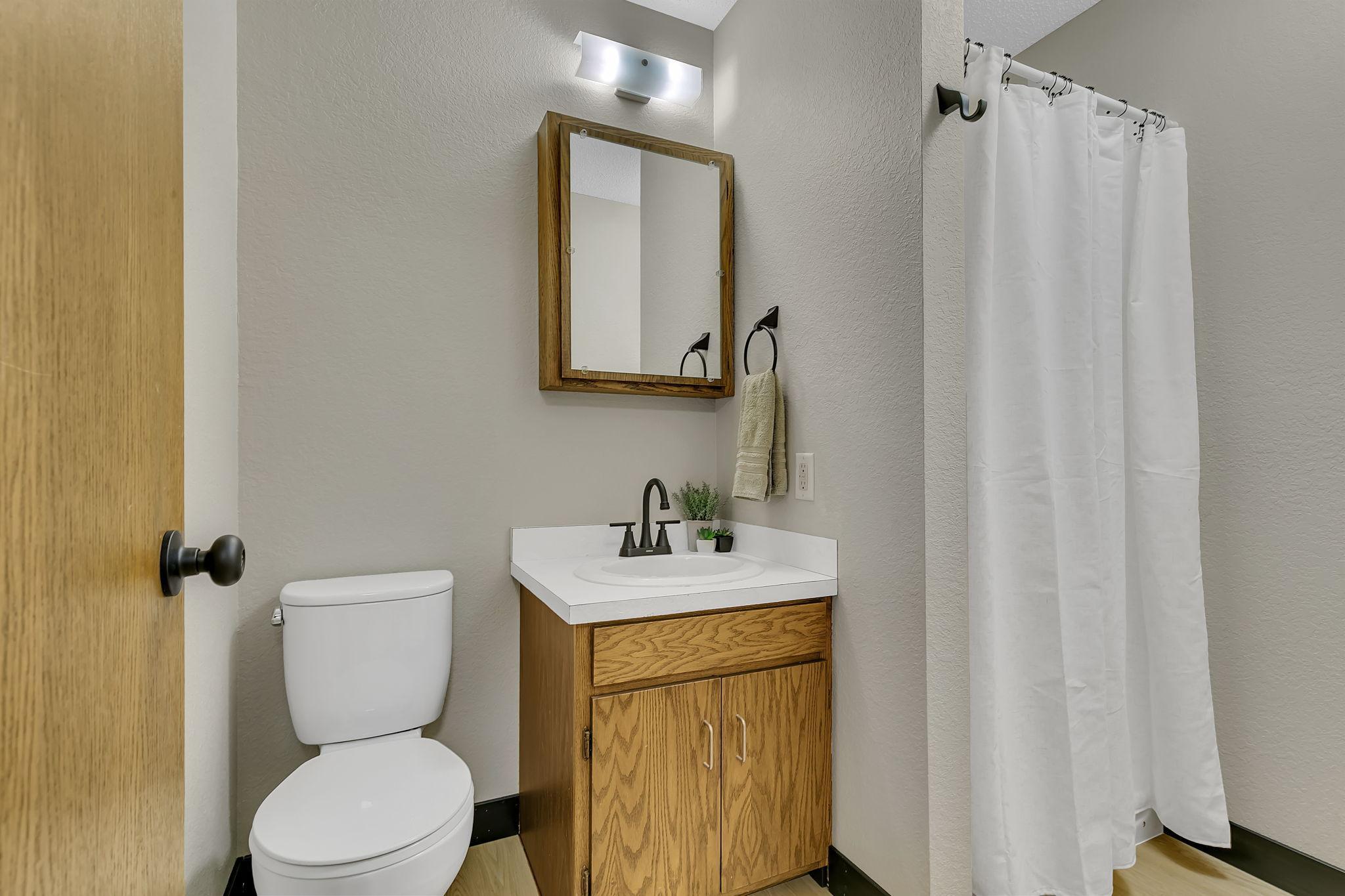 Clean 3/4 bathroom on he main level services the large primary owners wing.