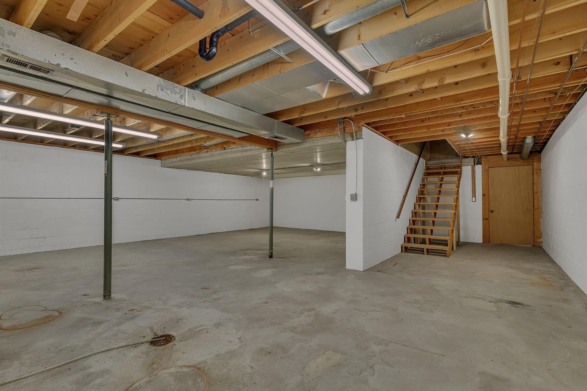 Unfinished basement presents excellent opportunity to finish and add living space. Steps seen here, exit into the 3rd garage stall.