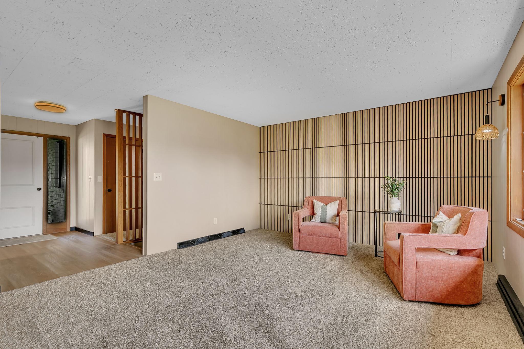 Upon entrance you are greeted by an open front living room. The addition of the slatted accent wall perfectly adds modern architecture in a home crafted in an era that inspired this very design.
