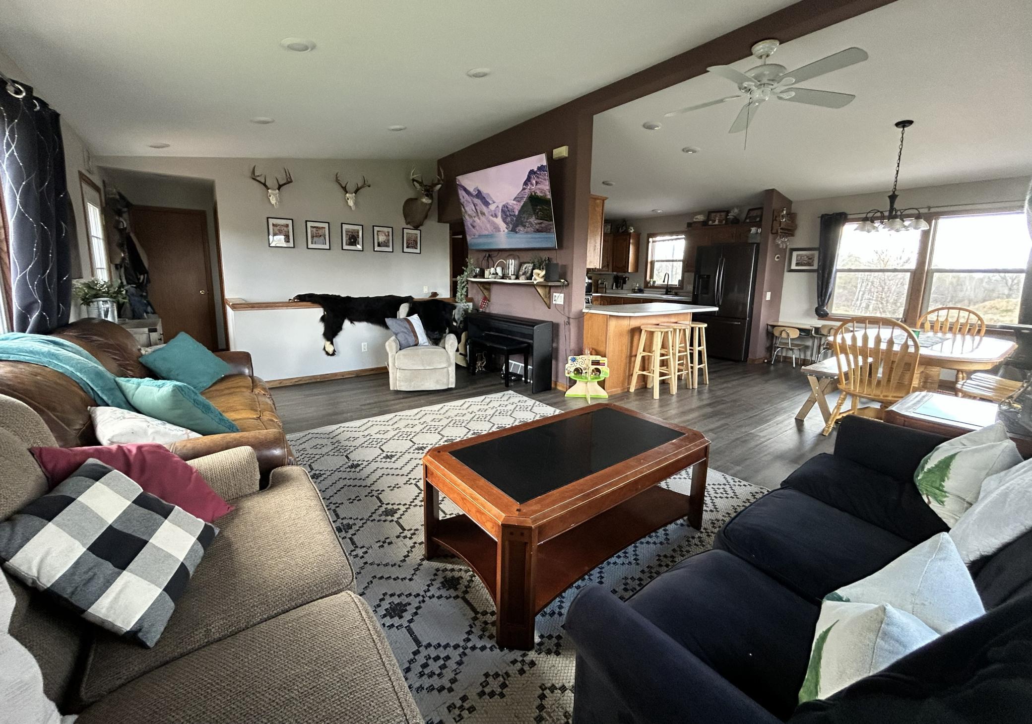 Spacious living room with vaulted ceiling opens to informal dining room and kitchen