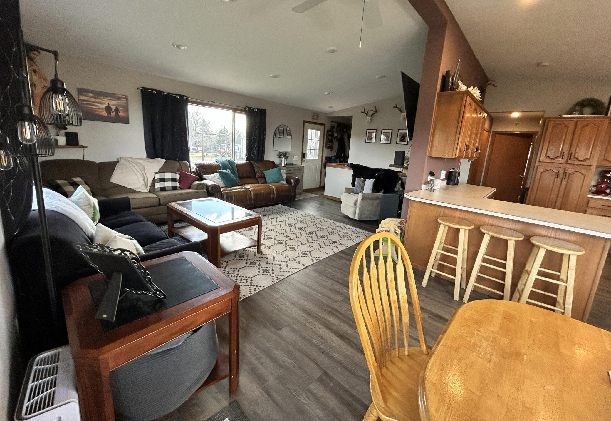 Spacious living room with vaulted ceiling opens to informal dining room and kitchen