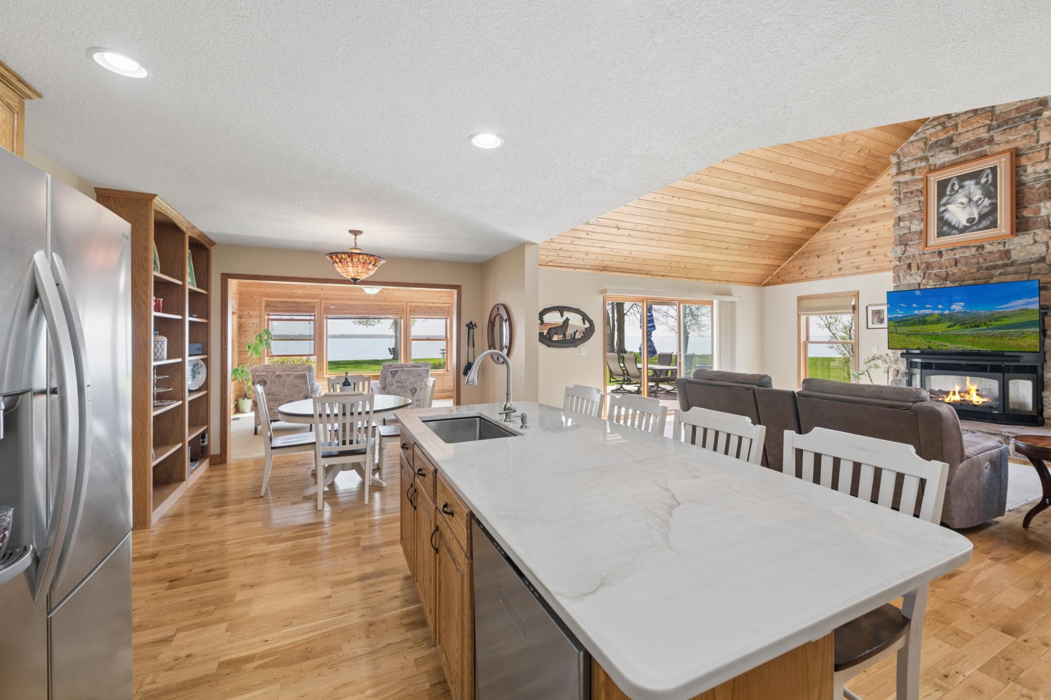 Upgraded kitchen with Brazilian quartzite countertops with so much seating in the near distance with the breakfast bar area, and the informal dining space.