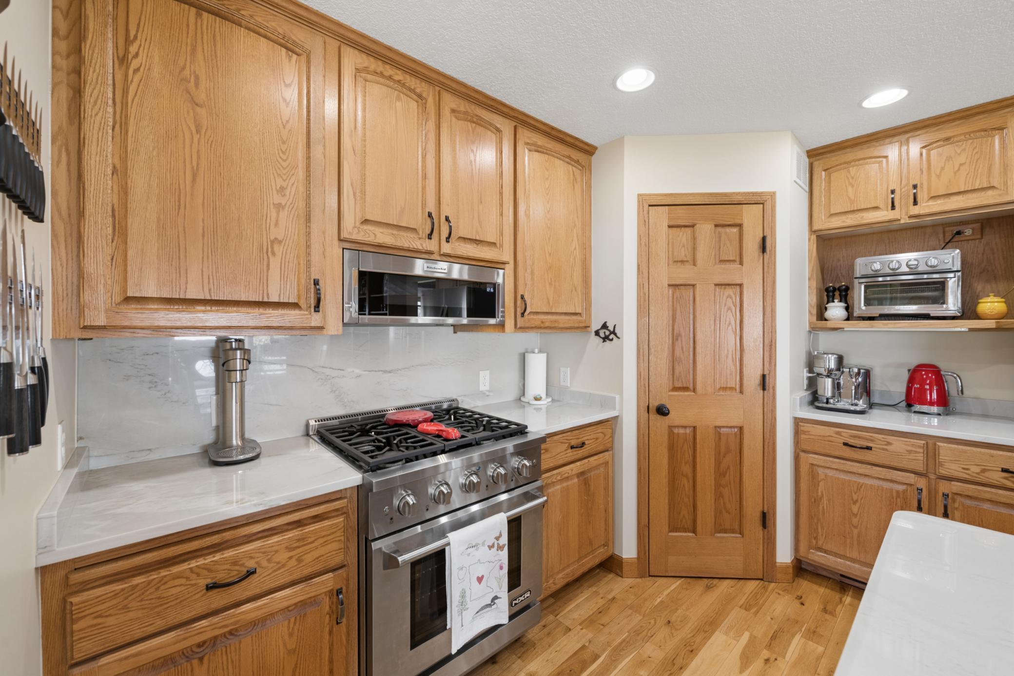 Kitchen area - with upgraded state-of-the art appliances with the Brazilian quartzite countertops and the full slab backslash. Check out the pantry for additional storage in the corner.