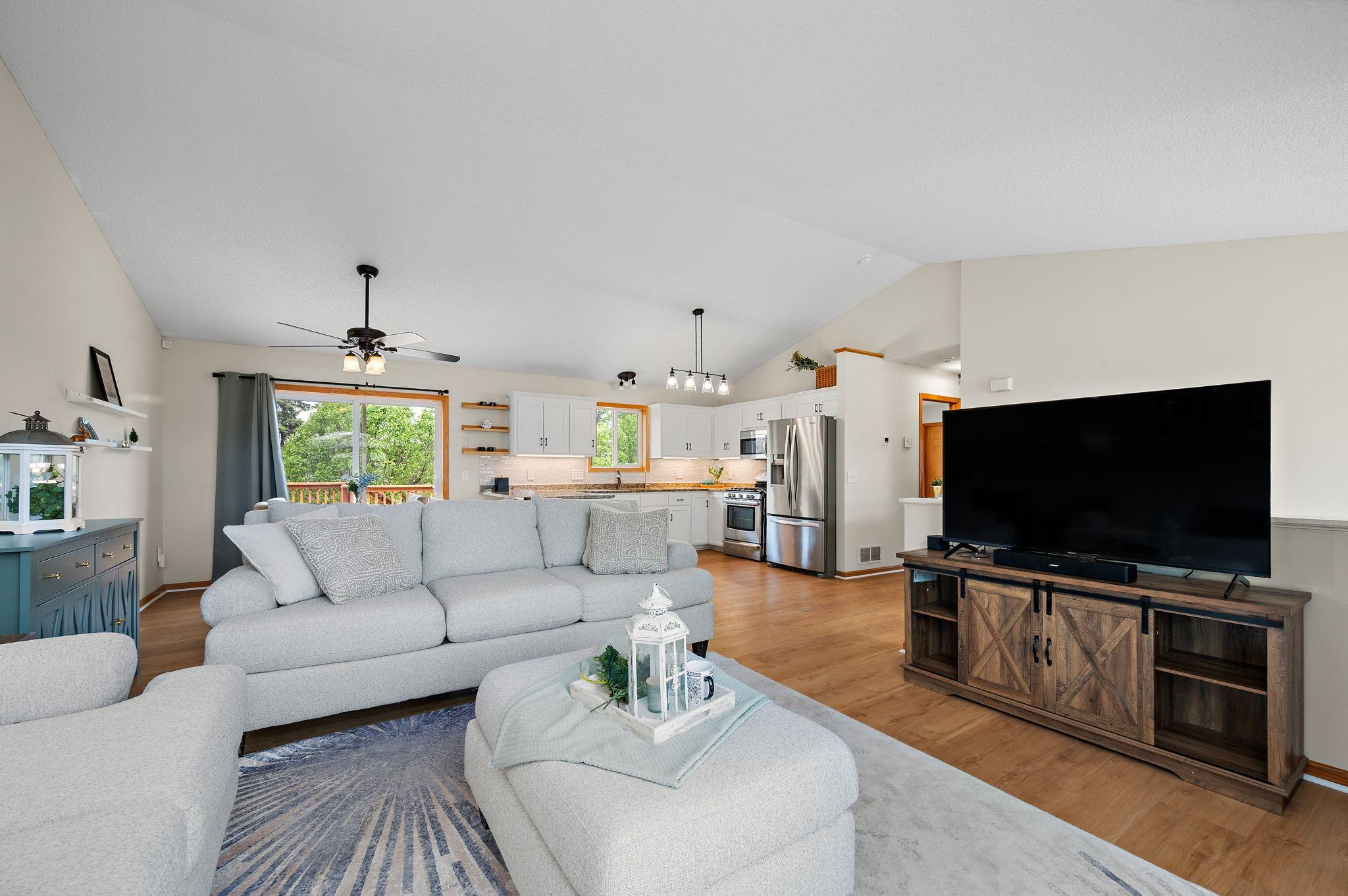 Boasting a bright, open floor plan with dramatic vaulted ceilings, the home features beautiful new flooring throughout