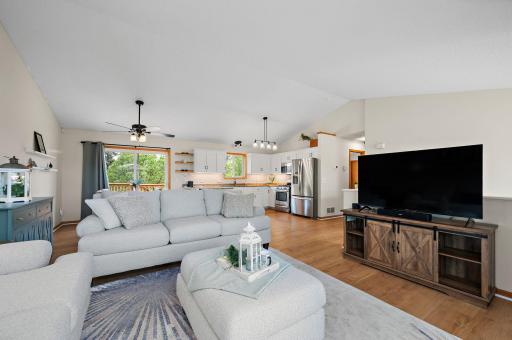 Boasting a bright, open floor plan with dramatic vaulted ceilings, the home features beautiful new flooring throughout