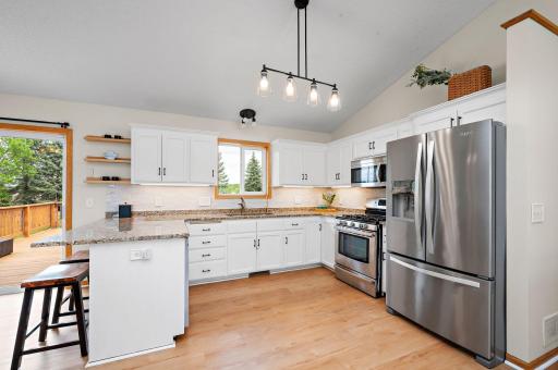 Photo for 11144 14th Street NE, Hanover, MN 55341 - listing #7068013 The updated white kitchen is a chef's delight, complete with granite countertops, a convenient breakfast bar, stainless steel appliances, and a stylish tile backsplash