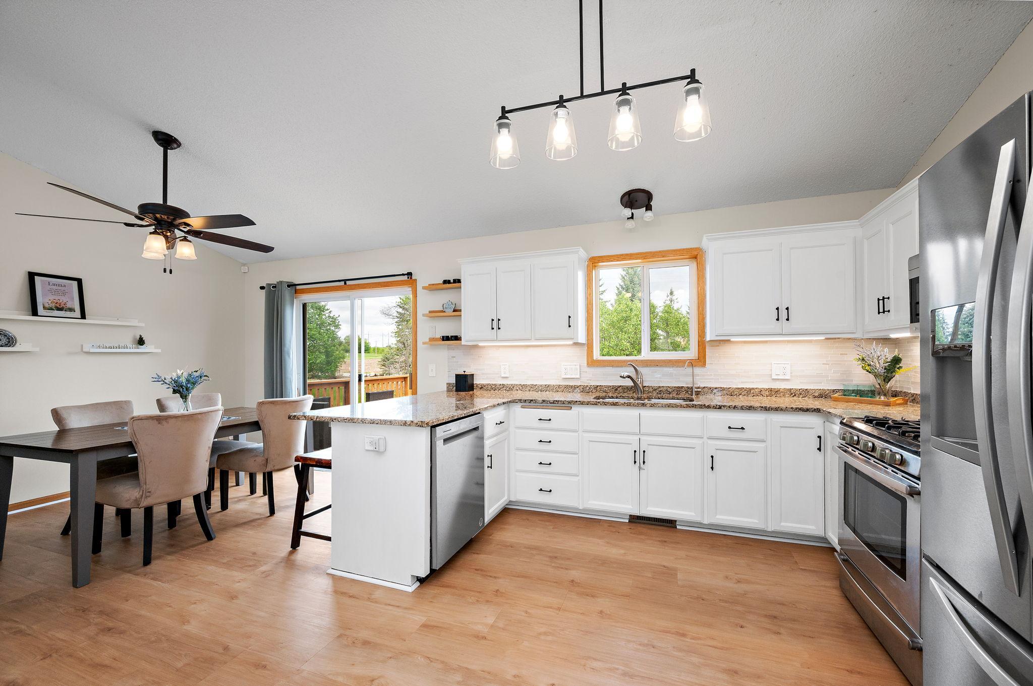Boasting a bright, open floor plan with dramatic vaulted ceilings, the home features beautiful new flooring throughout