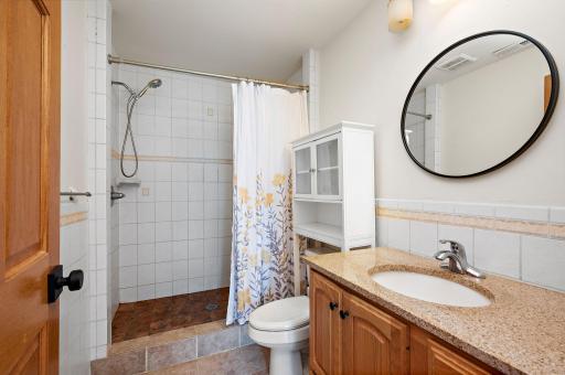 3/4 bathroom showcasing a new vanity and a custom tile shower surround
