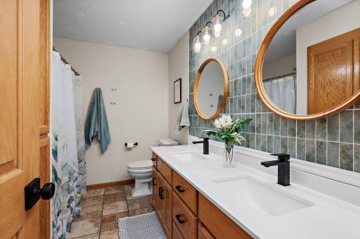 Main Floor full bathroom beautifully upgraded with a new countertop, tile backsplash and a large linen closet!