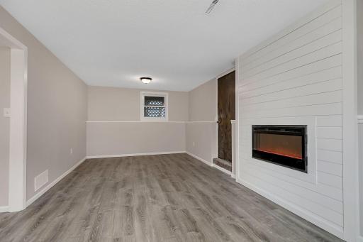 Lower level family room with an electric fireplace as another focal point.