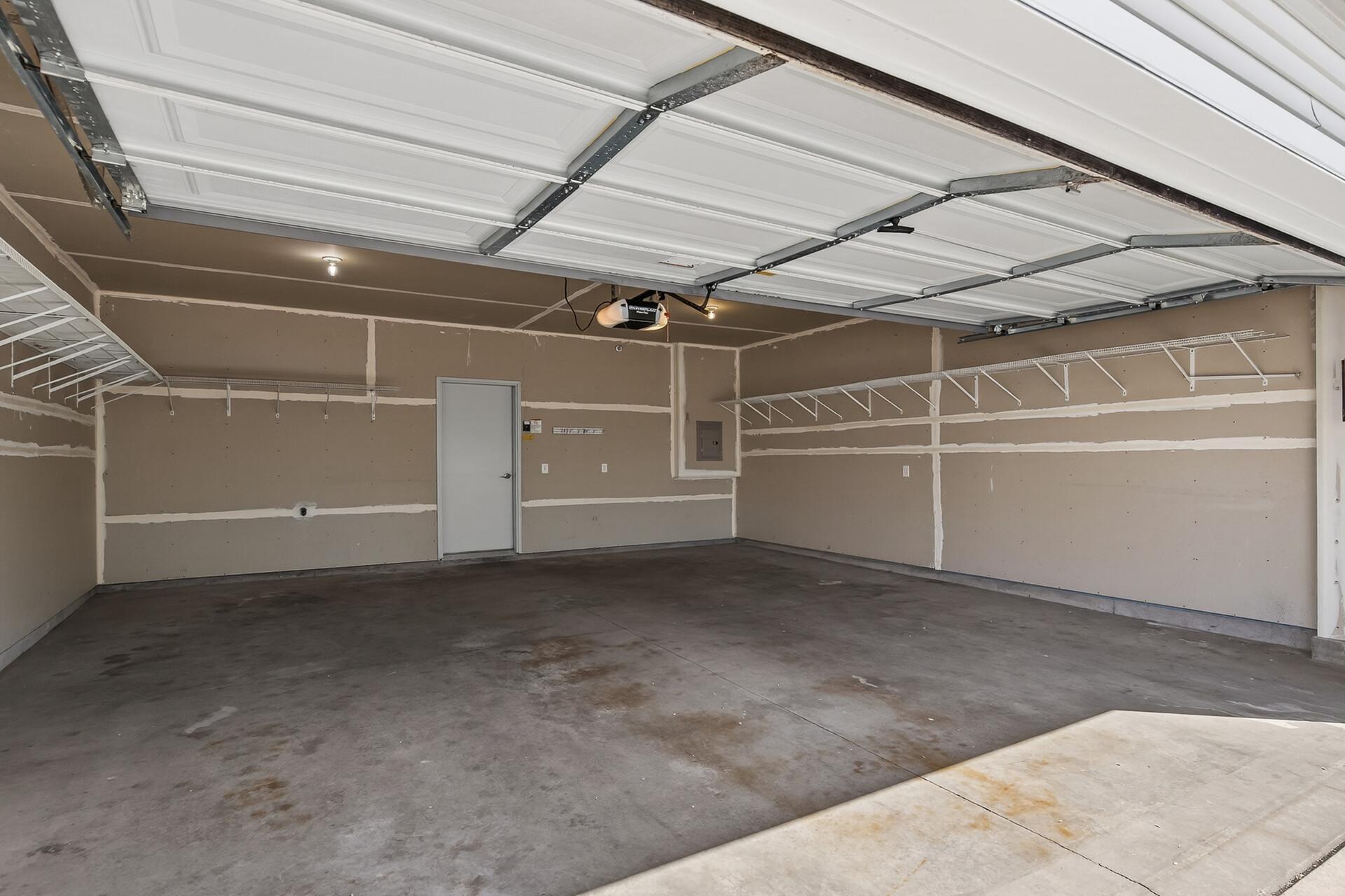 Two car garage stall with shelving already installed to save space and keep it organized
