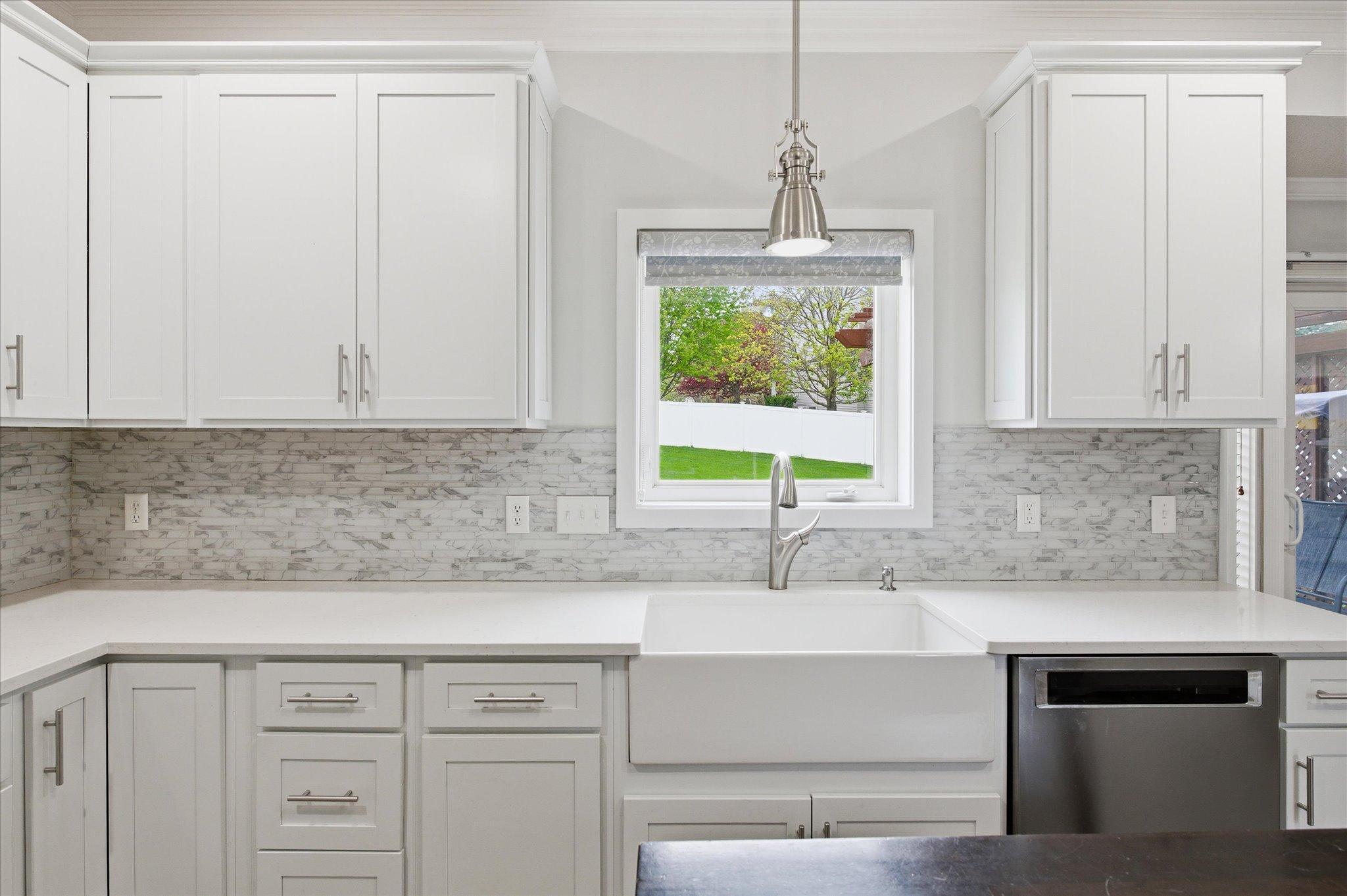 Quartz counter tops and backsplash, farm sink, touchless faucet and garbage drawer