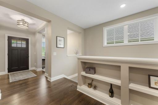 The Foyer has wonderful space and light coming in -- the hall, leads to the living space/kitchen -- gorgeous built-in shelving and transom windows. The use of space and light within the home is so beautiful!