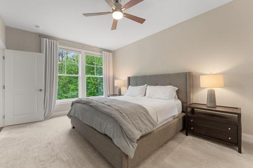 The main-floor, primary suite is large enough to hold all of your furniture! Views of the backyard/wooded lot also add to the peaceful oasis!