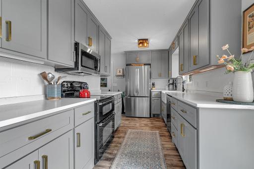 Beautiful quartz countertops, double oven, stainless steel appliances and a farmhouse window sink