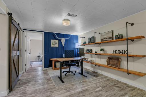 Second half of the lower level is currently used as a home office. Fun accent wall give charater to the space