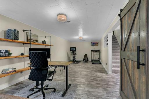 Large space with LVP flooring and updates accents of sliding barn doors and modern shelving